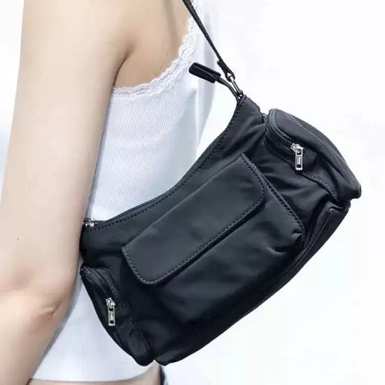 Black nylon shoulder bag with two pockets showing side line detail and 24cm dimensions