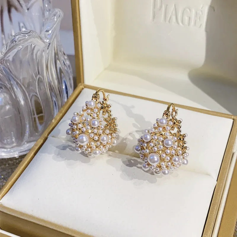 Gold-coloured copper basket flower earrings with pearl inlay and small rice-shaped bead detailing