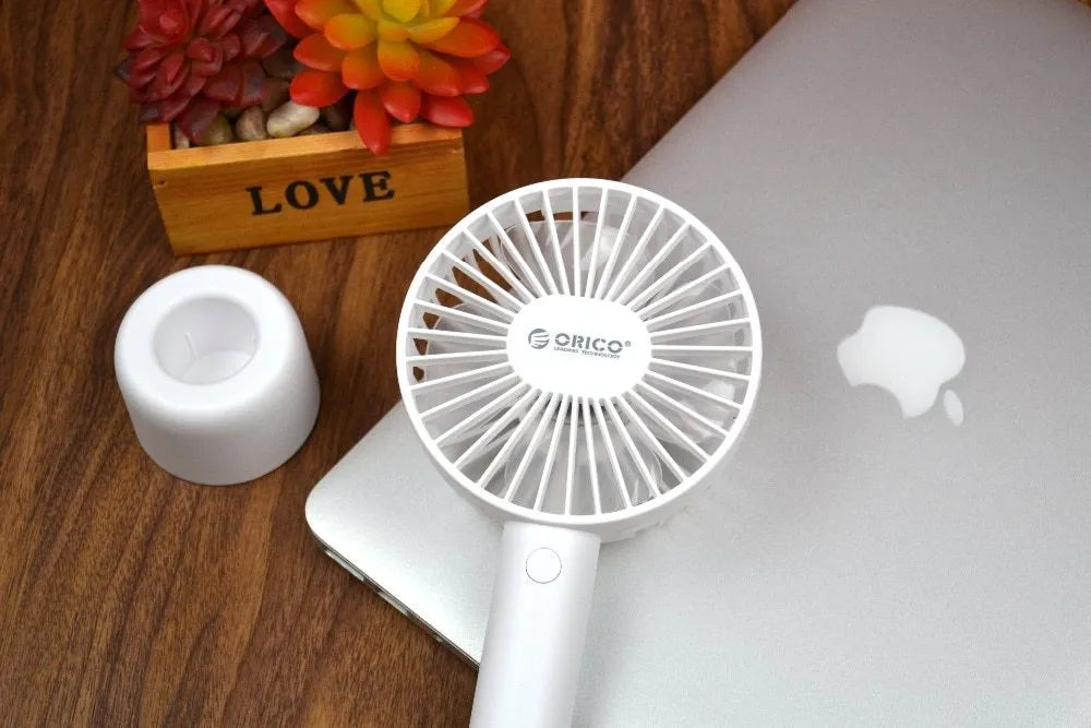 White ORICO FH1 portable USB desktop fan with rechargeable battery on a table.