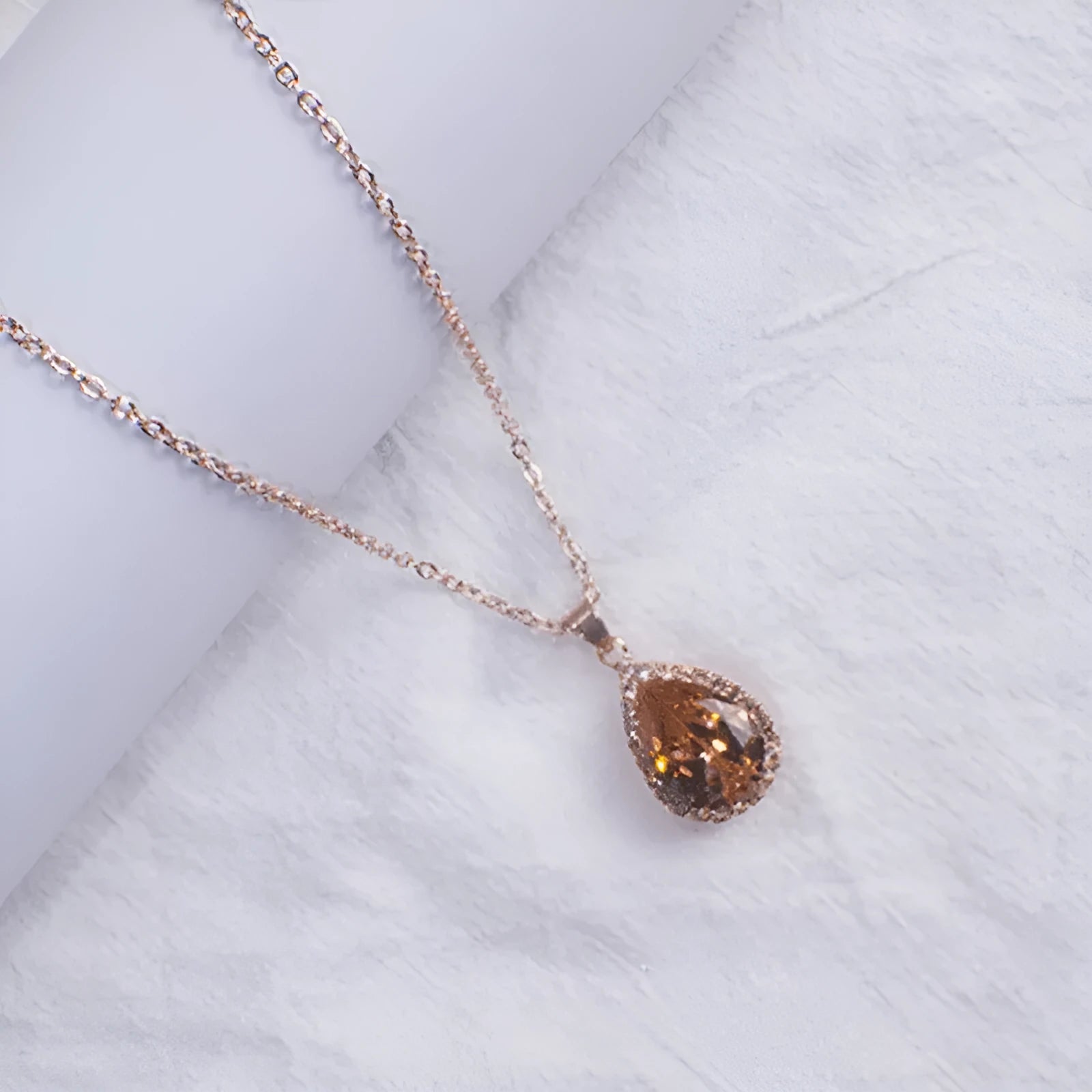 Pink drop shape women's necklace with geometric pendant design and rhinestone details