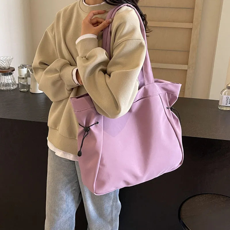 A soft folding Oxford cloth tote bag in a choice of five colours: black, light grey, dark grey, brown, and purple.