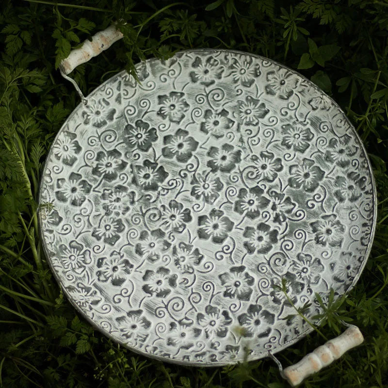 Round wrought iron storage tray in two sizes on a wooden surface