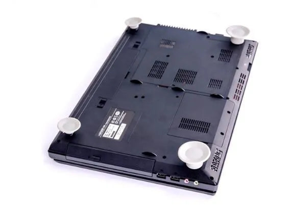 Grey plastic laptop cooling stand with four non-slip pads on a flat surface