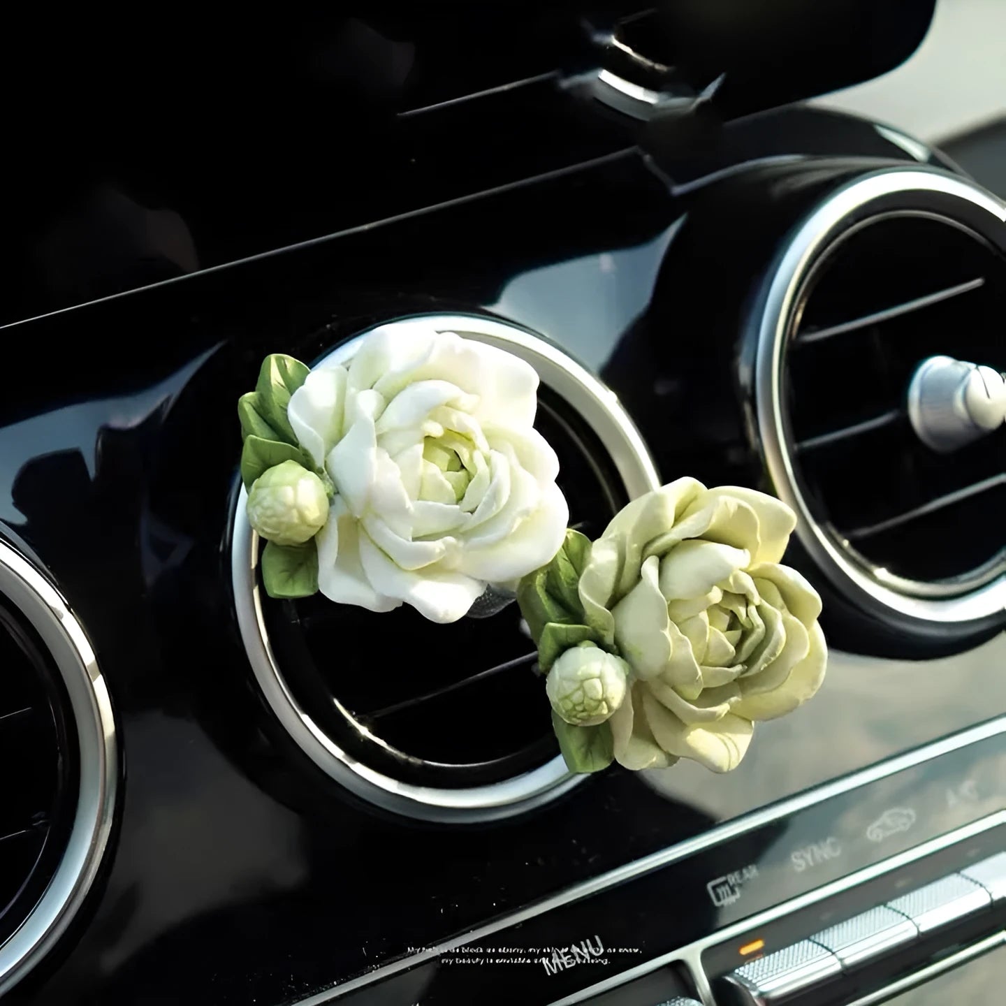 Solid jasmine car perfume diffuser clipped on a car air vent in off white or fresh green.