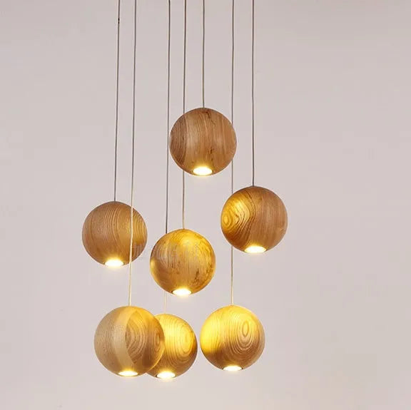 Nordic style solid wood ball chandelier pendant light hanging from ceiling on adjustable cord.