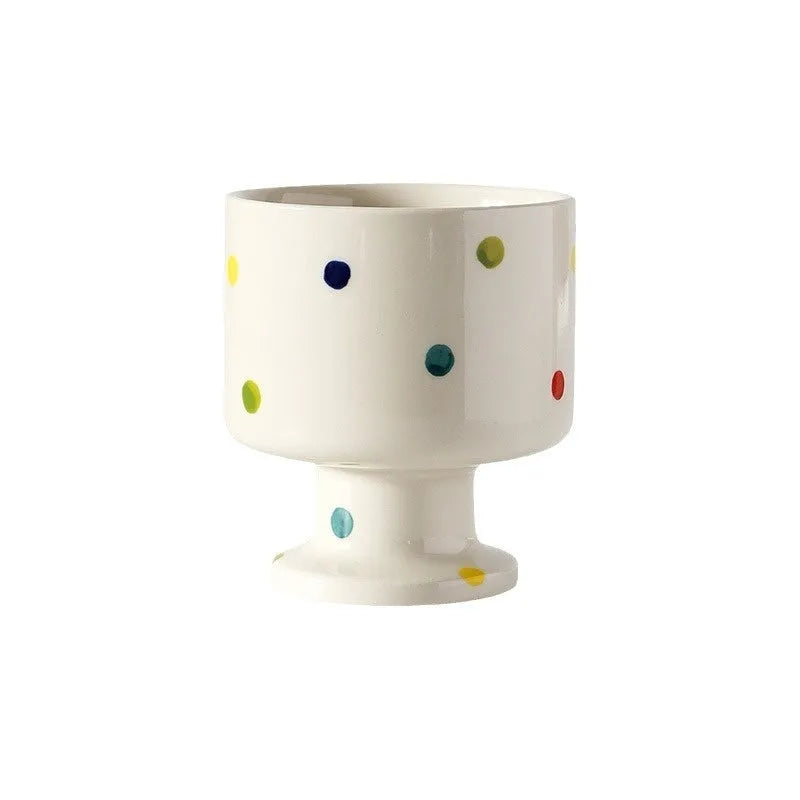 Hand-pinched irregular shaped ceramic mug in a solid colour on a table