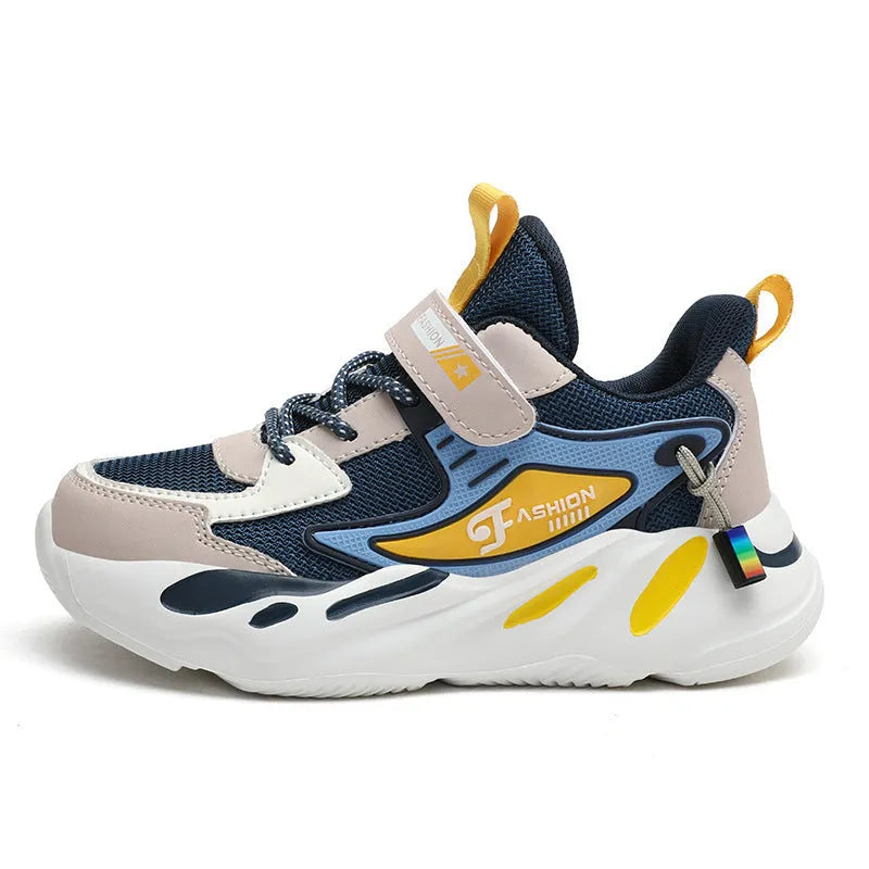 Boys sports running shoes in dark blue with a mesh upper and Velcro strap, shown on a hard ground surface.