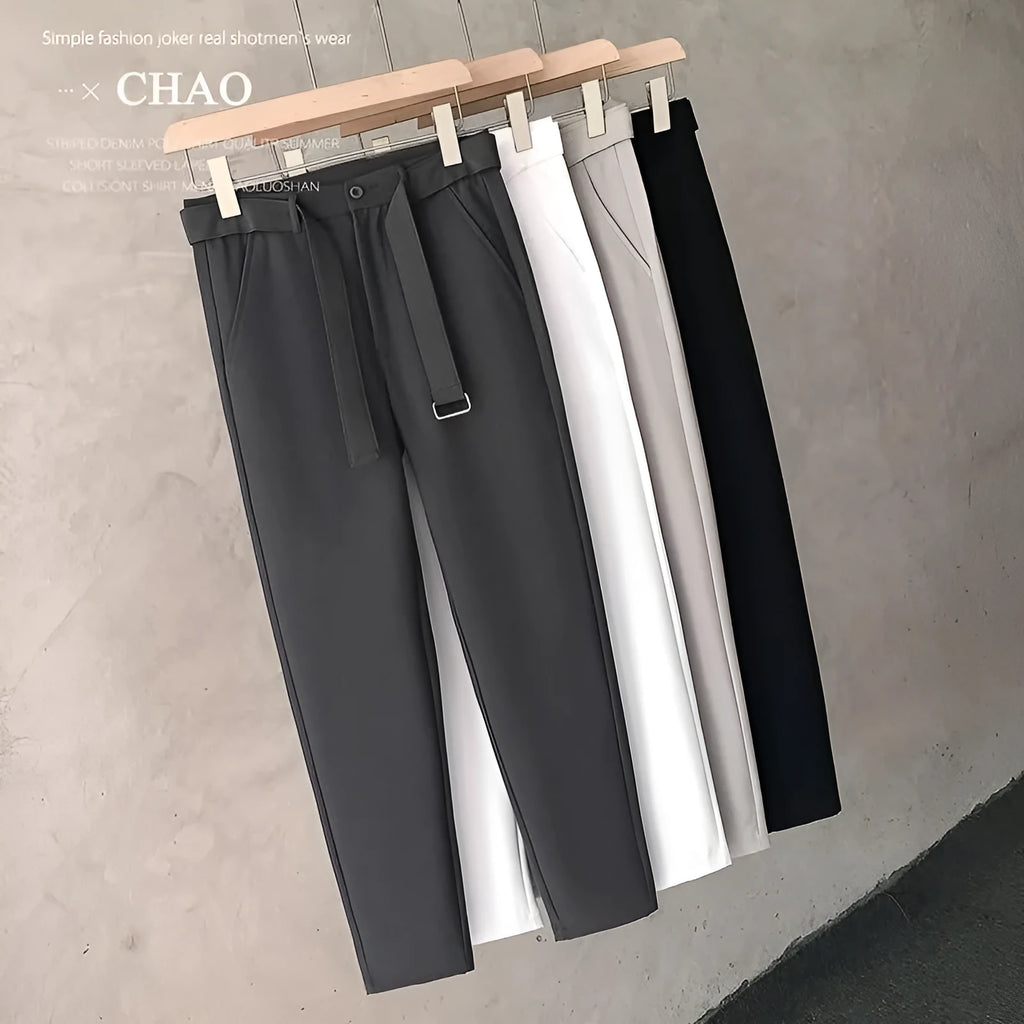 Boy wearing slim straight tapered wool trousers in a grey colour, showing the straight leg opening and belt loops.