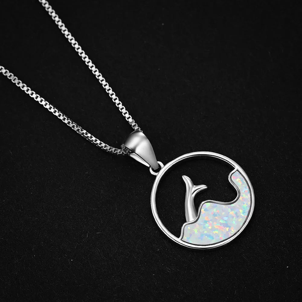 Gold tone geometric fishtail pendant necklace with a round blue opal centre on a chain.