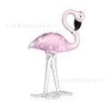 Pink crystal flamingo decorative ornament on a table, modern minimalist style.