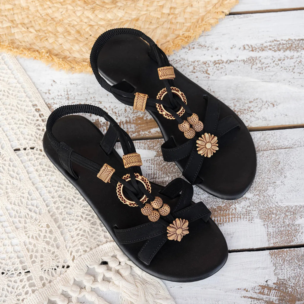 Black women's flat ethnic style beach sandals with beaded weave upper and elastic band.
