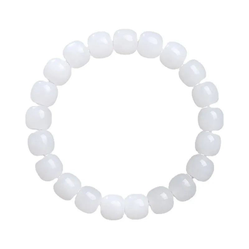 White Hetian jade barrel bead bracelet on a wrist, showing smooth oval beads on a string.