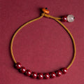 Hand-woven cinnabar and Hetian jade bracelet with geometric design showing natural colour variation