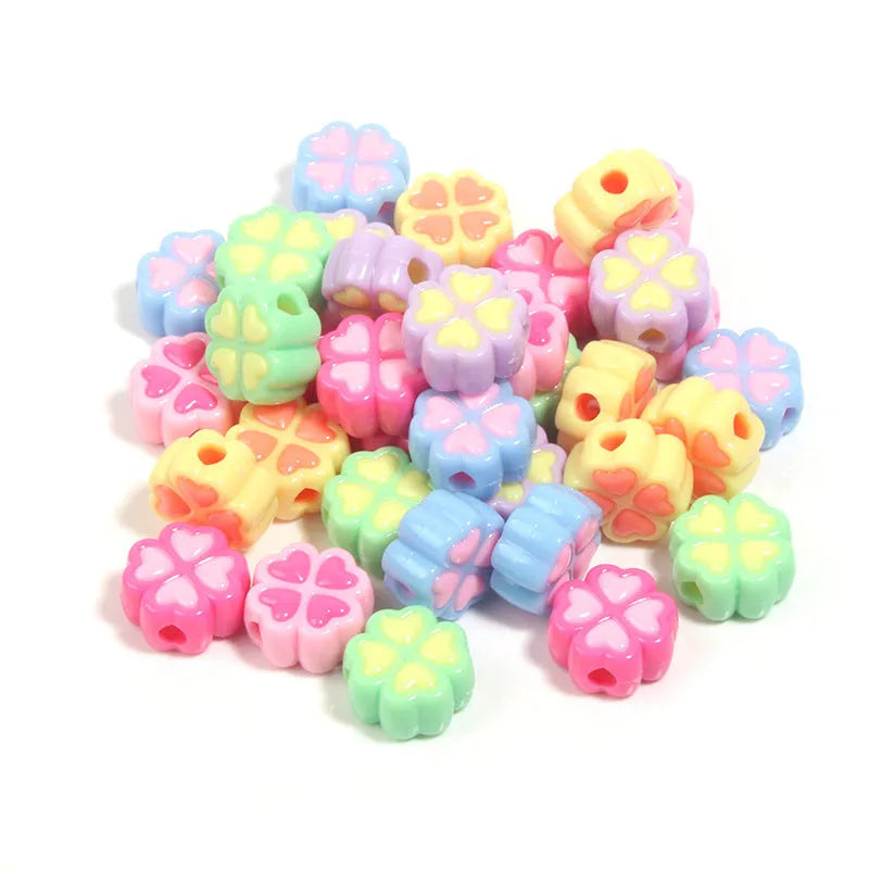Frosted acrylic four-leaf clover shaped beads in mixed colours on white background