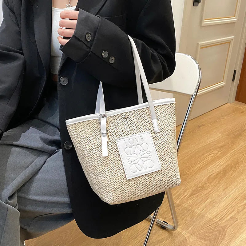 Straw woven women's shoulder bag in black with sewing thread detailing and three-dimensional pockets
