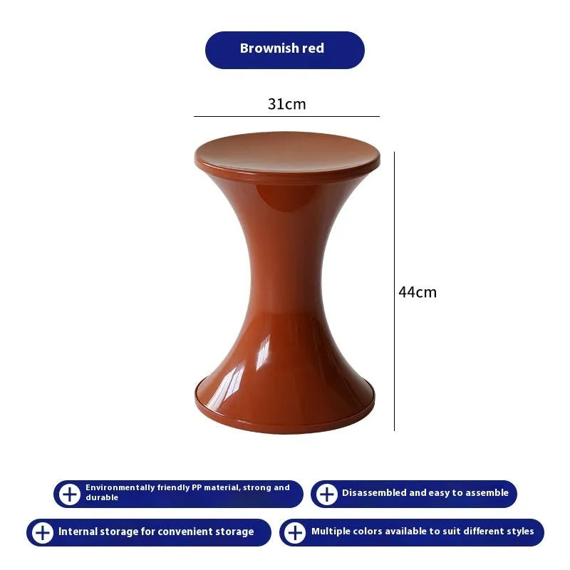 Hourglass-shaped plastic shoe changing stool in green colour on a wooden floor.