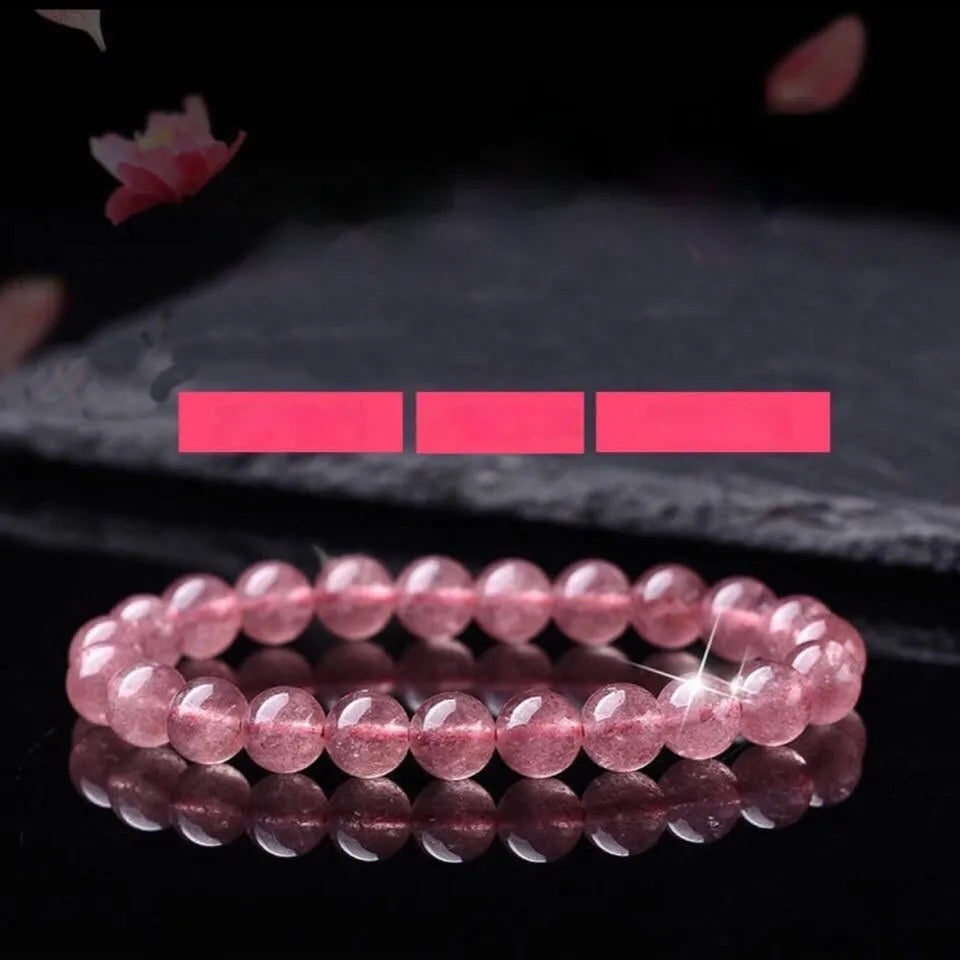 Women's strawberry quartz crystal bracelet in polished pink beads on a white background.