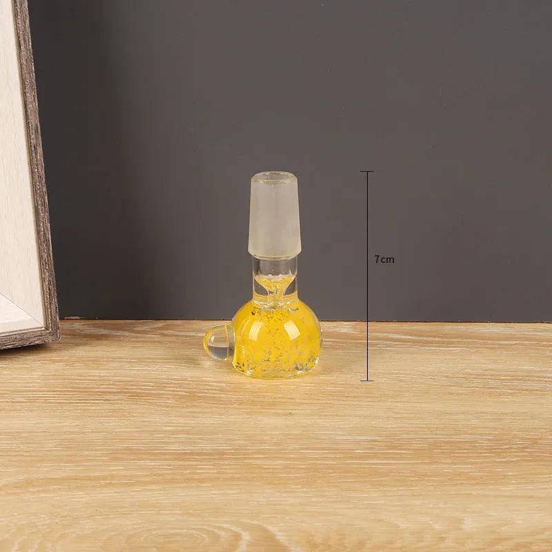 Transparent coloured glass tobacco pipe, trumpet shape, 7cm tall, on a plain background.