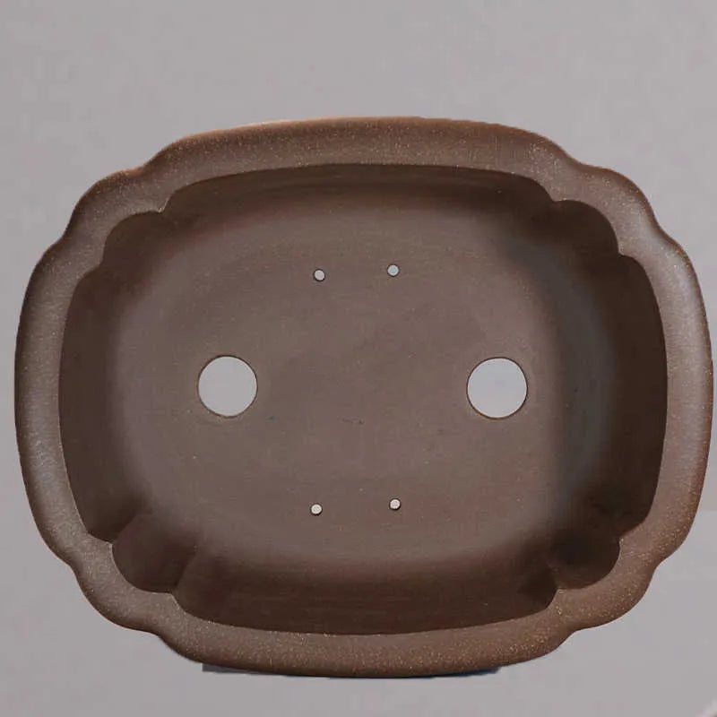 Handmade purple sand rectangular antique flower pot on a desktop.