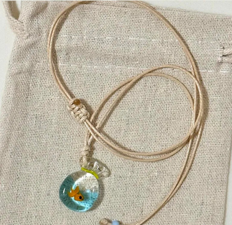 Women's coloured glaze small fish lucky bag pendant on a cotton linen clavicle chain necklace.
