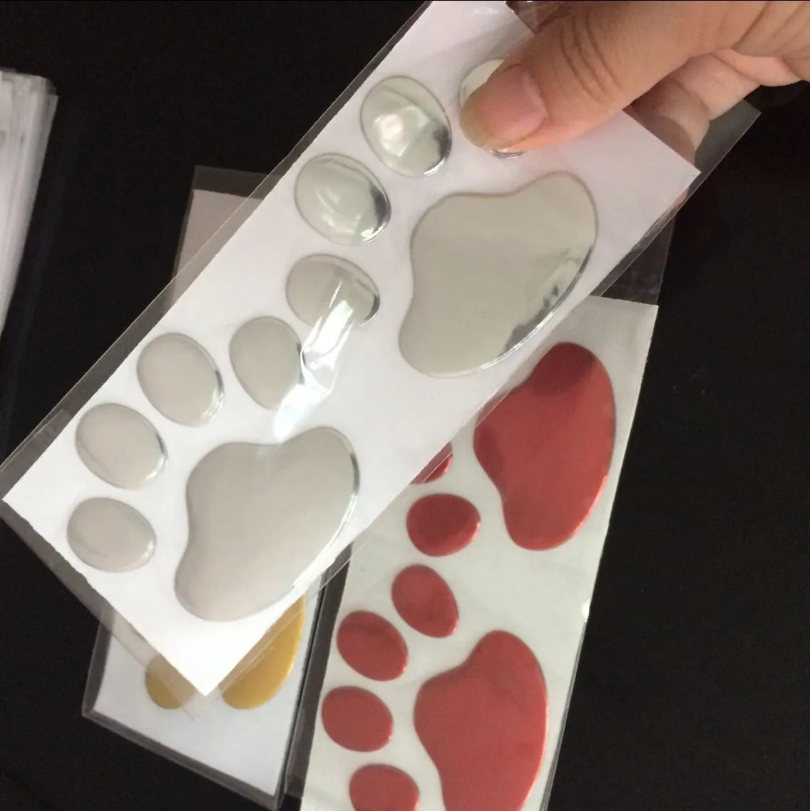 PVC car stickers showing hand-shaped brush design with dog footprints pattern in four colour options