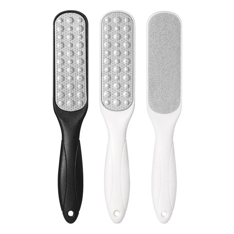 Stainless steel foot grinder tool with white and black double-sided abrasive files for callus removal.