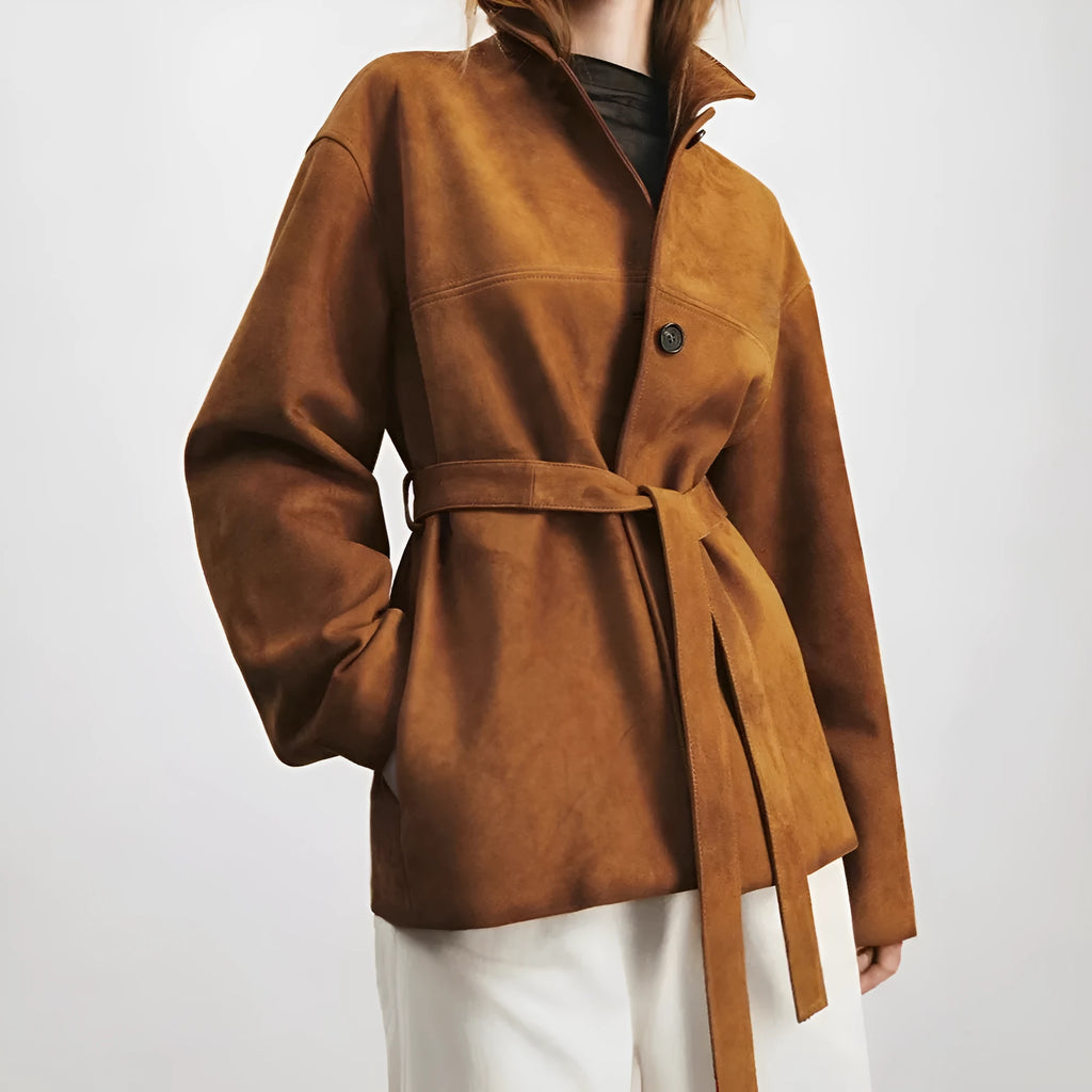 Women's belted caramel cashmere coat with leather stitching and a Peter Pan collar.