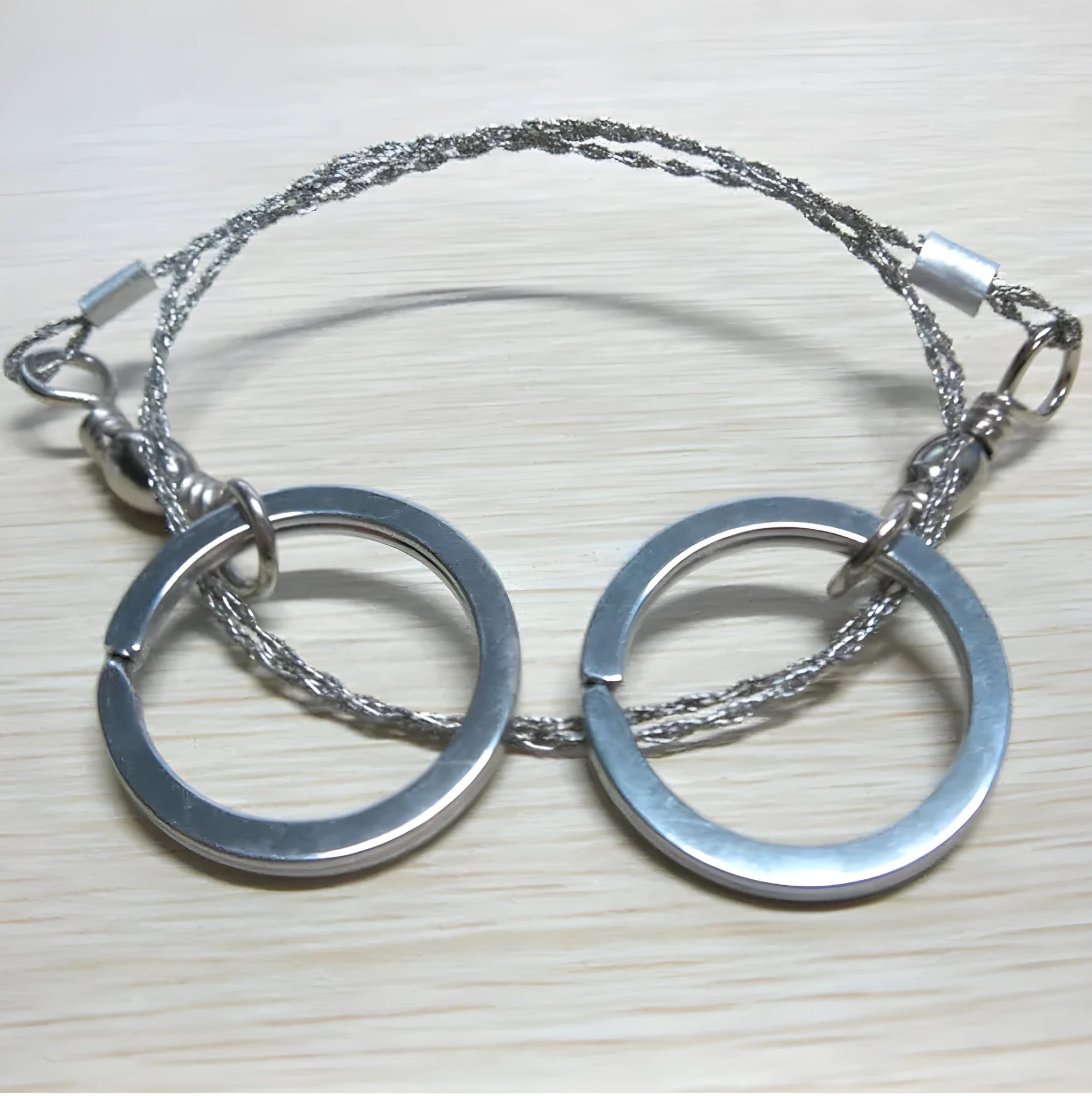 Survival wire saw with stainless steel blade, pull ring, and hoop handles for outdoor cutting
