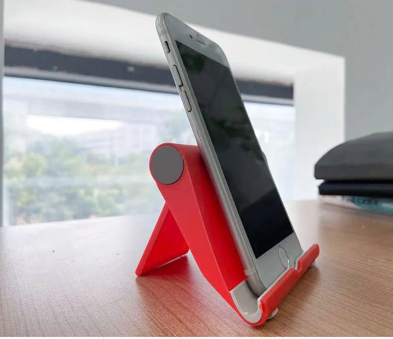 Black PE folding mobile phone stand holding a tablet at an angle on a desktop.