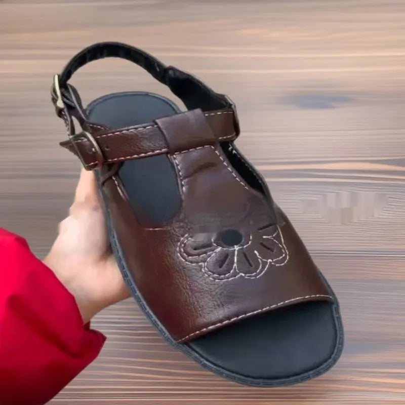 Men's black embroidered floral beach sandals with a flat heel on a plain background.