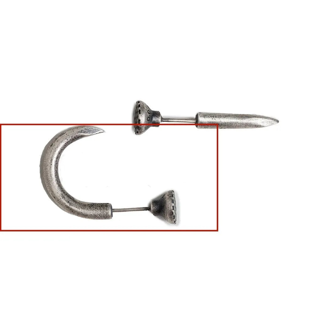 Close-up of a sterling silver punk stud earring with a retro nail design on an ear.