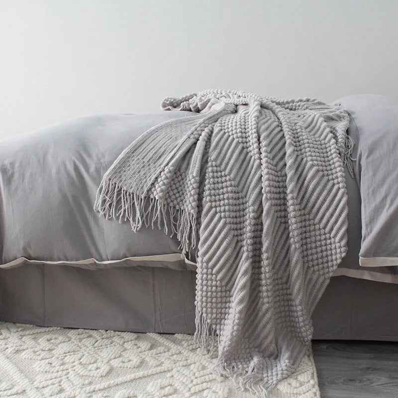 Small grey polyester fibre blanket folded to show its texture and colour.