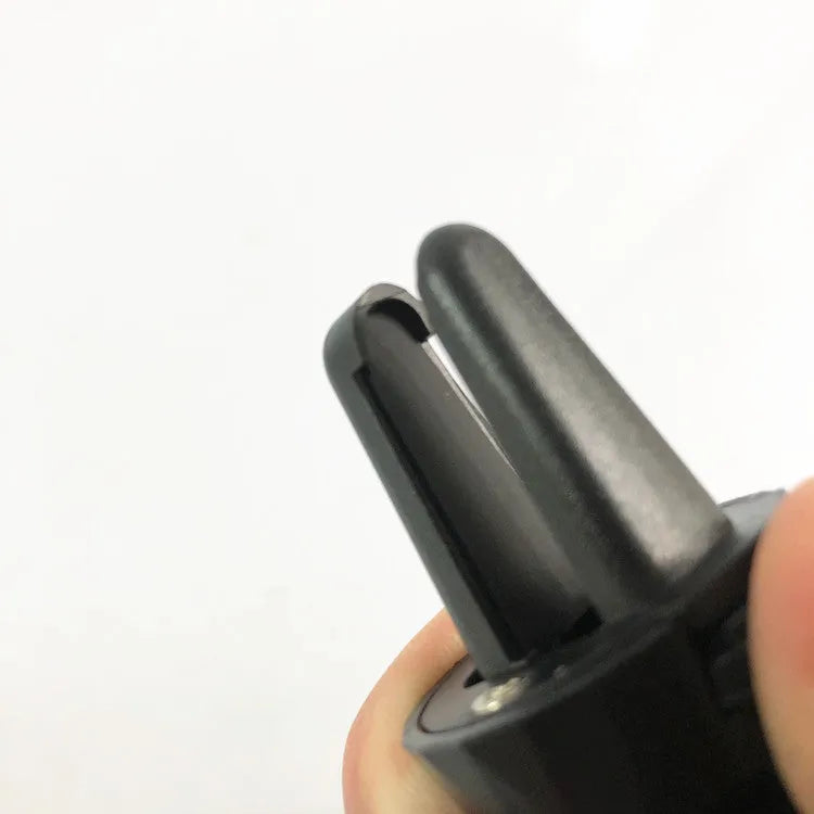 Black car phone holder mounted on car air vent with smartphone secured in adjustable clamp