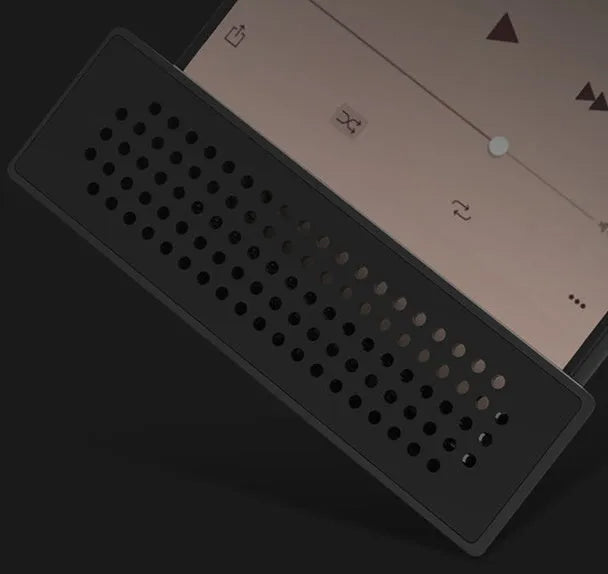 A small black plastic phone amplifier stand holding a smartphone on a desktop.