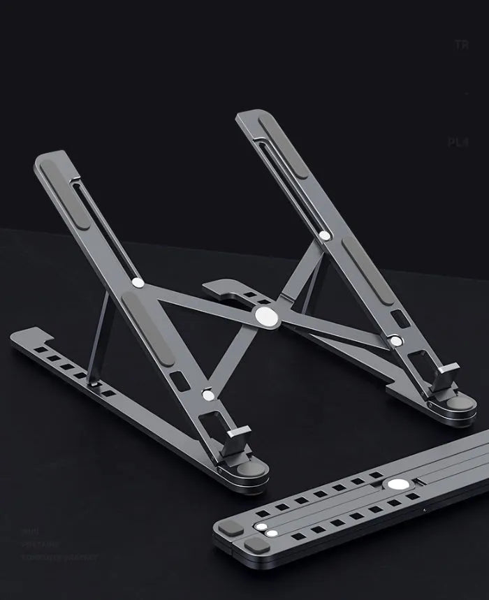 Aluminium foldable laptop stand in silver colour set to medium height with a laptop on top.