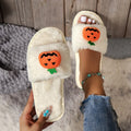 Yellow and white Halloween pumpkin cartoon design plush slippers with an open toe and textured sole.