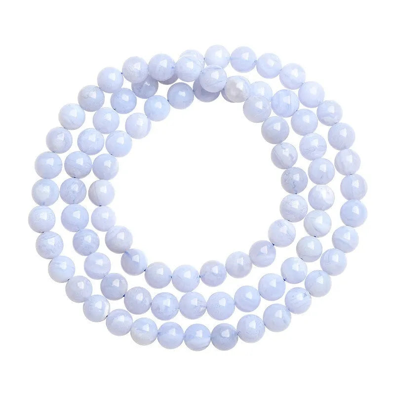 Blue striped agate bead bracelet with Ruyi charm on a wrist.