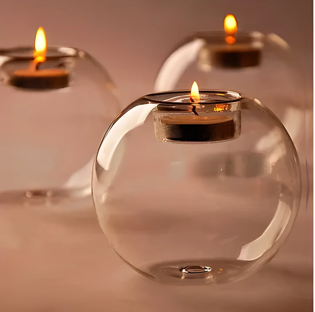 Handmade round hollow glass candle table centrepiece on a wooden surface.