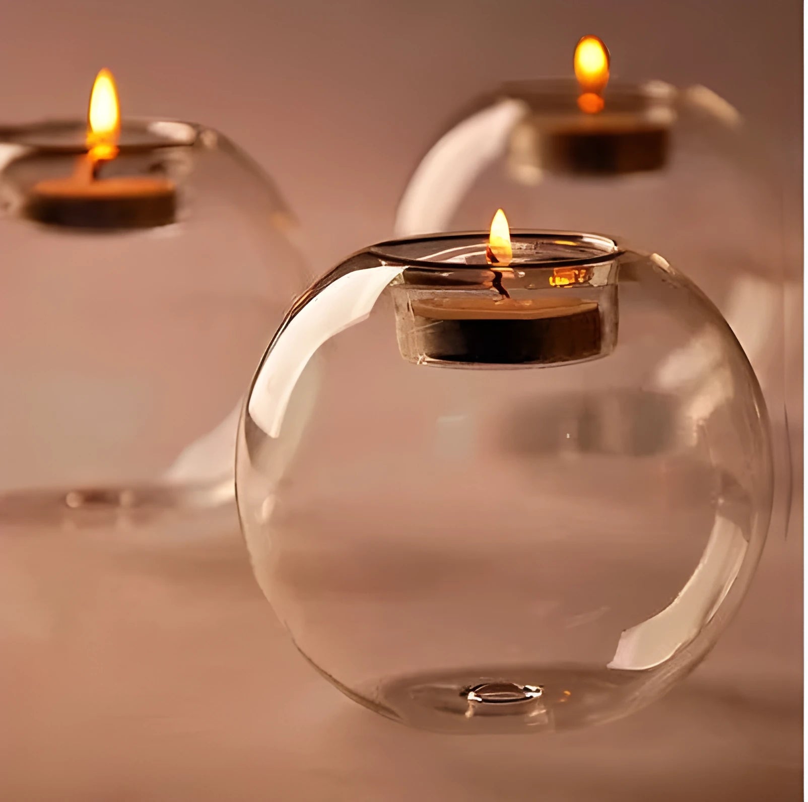 Handmade round hollow glass candle table centrepiece on a wooden surface.