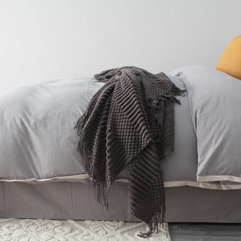 Small grey polyester fibre blanket folded to show its texture and colour.