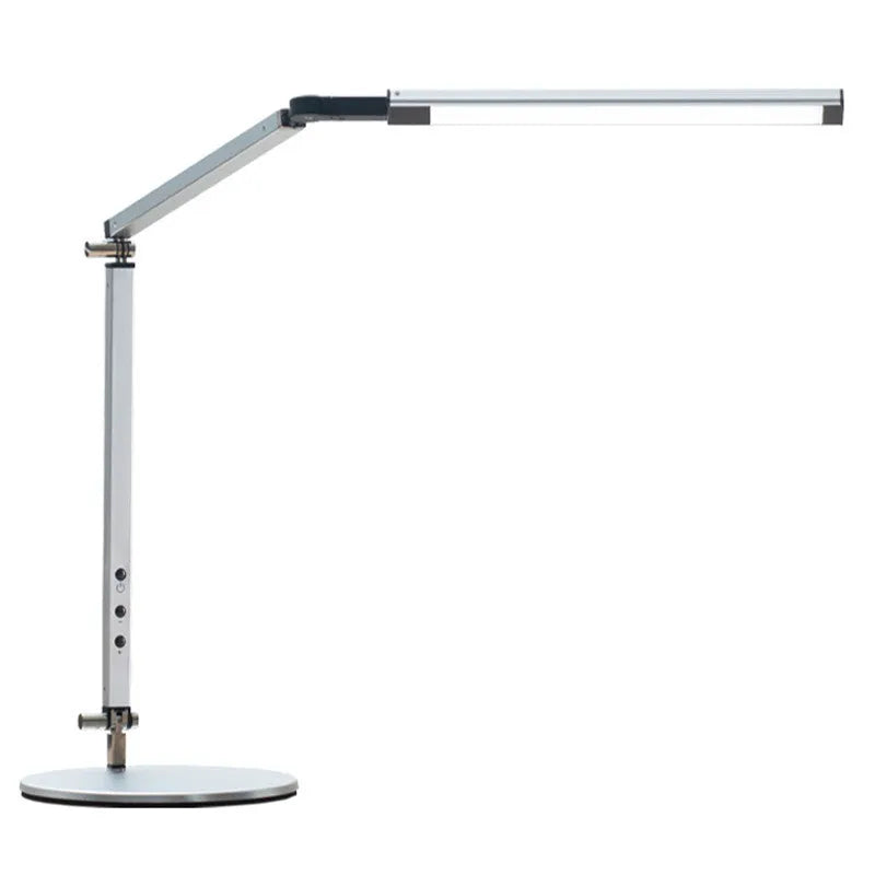 Aluminium LED desk lamp with a folding clip, remote control, and black finish on a desk.