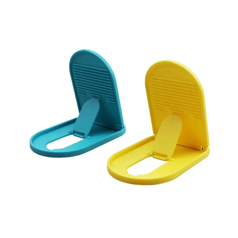 Adjustable plastic mobile phone stand in multiple colours on a table, holding a smartphone at an angle