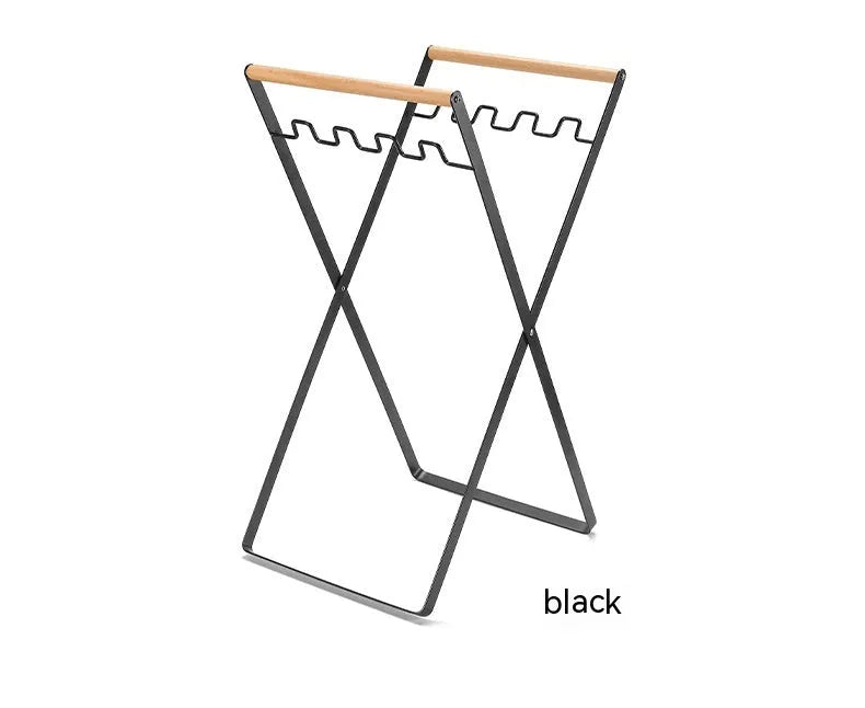 Black folding iron trash storage rack with a wooden handle holding a bin bag.