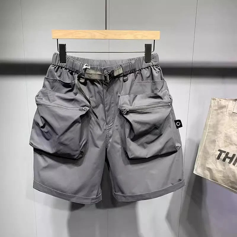 Men's loose-fit black work shorts with pockets, shown on a model, above the knee length.