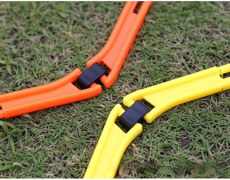 Set of six bright green, orange, and yellow foldable hexagon football agility training rings laid out on grass.