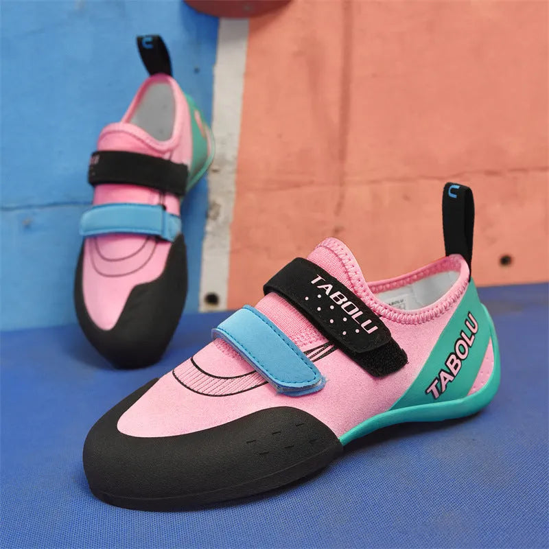 A pair of Velcro closure rock climbing shoes with a non-slip rubber sole in a black and red colour scheme.