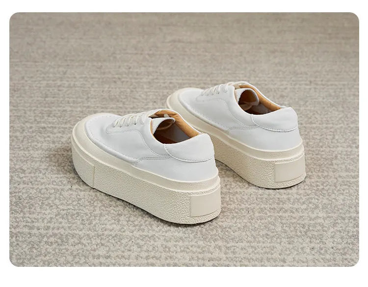 Women's black embossed leather platform sports shoes with round toe and white rubber sole on a white background.