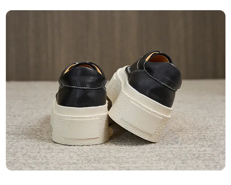 Women's black embossed leather platform sports shoes with round toe and white rubber sole on a white background.