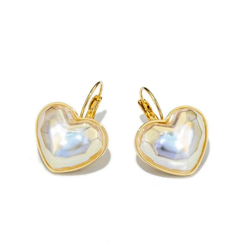 A pair of gold-coloured minimalist alloy ear clip earrings for women on a plain background.