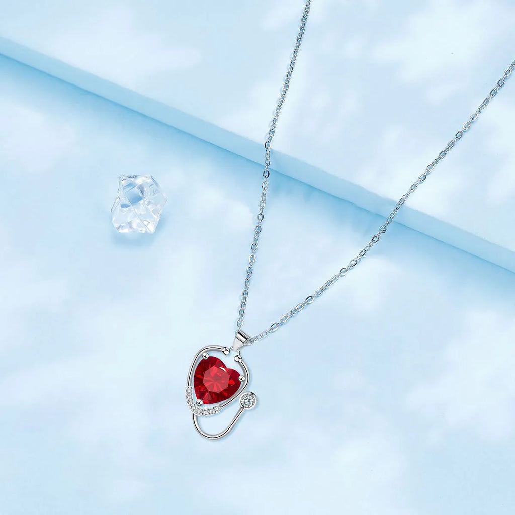 Women's copper necklace with a red diamond electroplated pendant showing stethoscope, wings, and cross design.